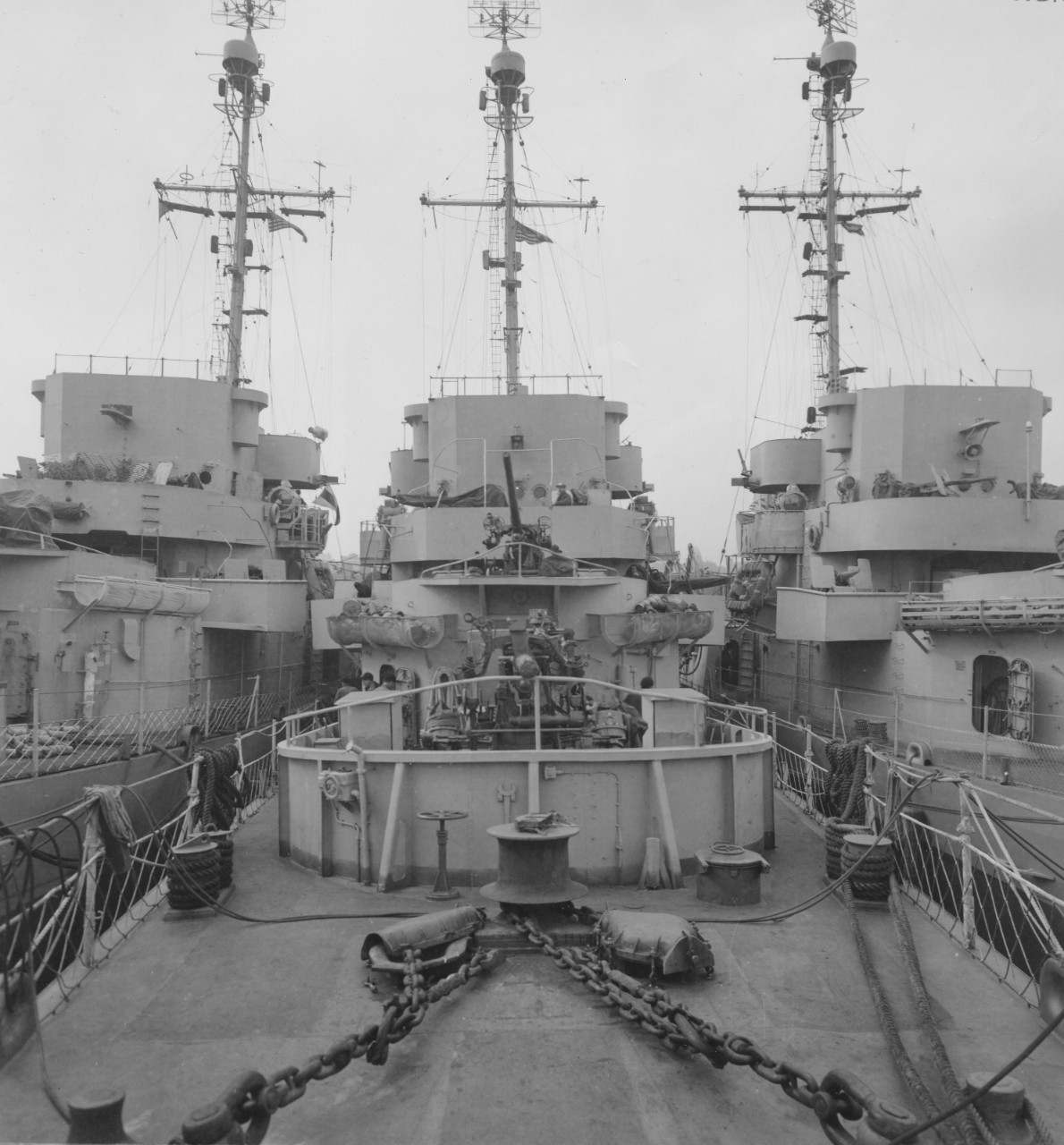Standard practice with dock space at a premium, Fechteler (center), lies nested with two sister ships, New York Navy Yard, 31 March 1944. Looking aft from the foc’sle one sees the forward 3-inch/50 caliber dual-purpose guns (Mt. 31 and Mt. 32), w...