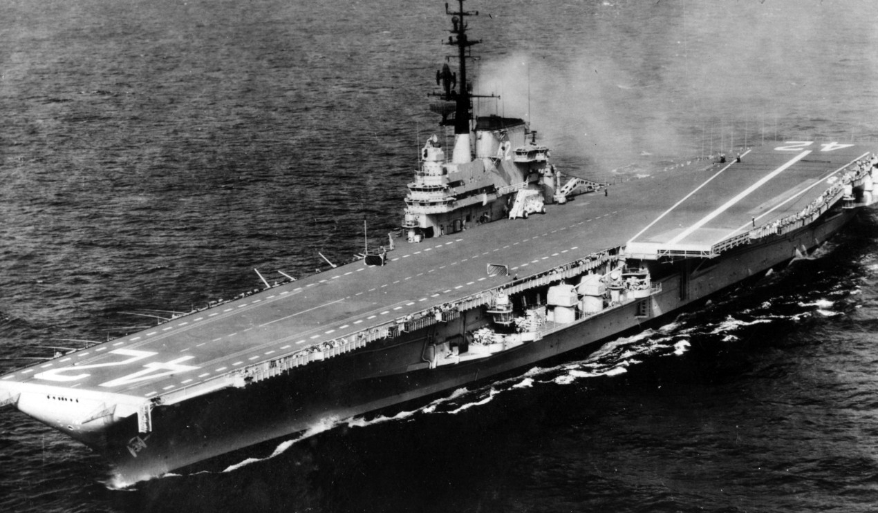 The ship emerges from the yard work with an entirely new silhouette, and her angled flight deck is clearly visible in this port bow image taken sometime after her recommissioning, 6 April 1956. (Naval History and Heritage Command Photograph UA 54...