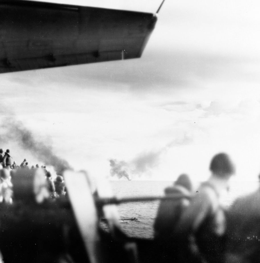 Sailors on board Kitkun Bay watch in horror as Gambier Bay burns and falls behind, 25 October 1944. (U.S. Navy Photograph 80-G-287512, National Archives and Records Administration, Still Pictures Division, College Park, Md.)