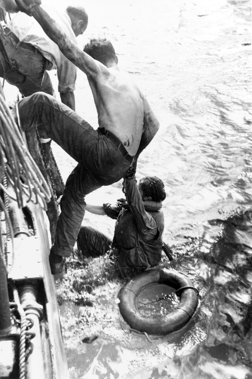 An unidentified ship rescues oil-soaked and exhausted survivors of the Battle off Samar, 26 October 1944. (Photographed by Pvt. William Roof, USA, U.S. Army Signal Corps Photograph 111-SC-278010, National Archives and Records Administration, Stil...
