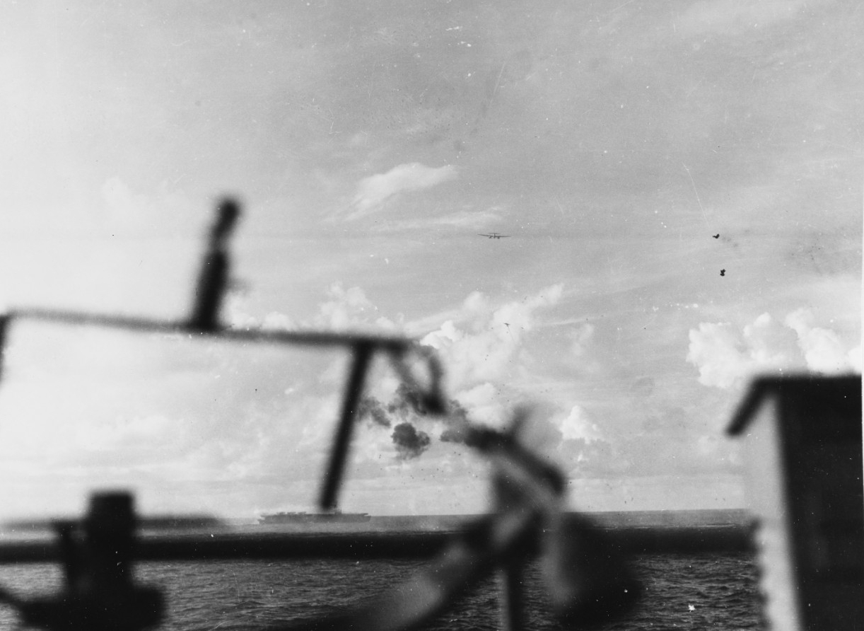 A Japanese twin-engine plane passes over Gambier Bay during the fierce fighting off Saipan, 18 June 1944. Kitkun Bay fights off her attackers in the center of the picture, and another enemy plane is visible under the first one. (U.S. Navy Photogr...