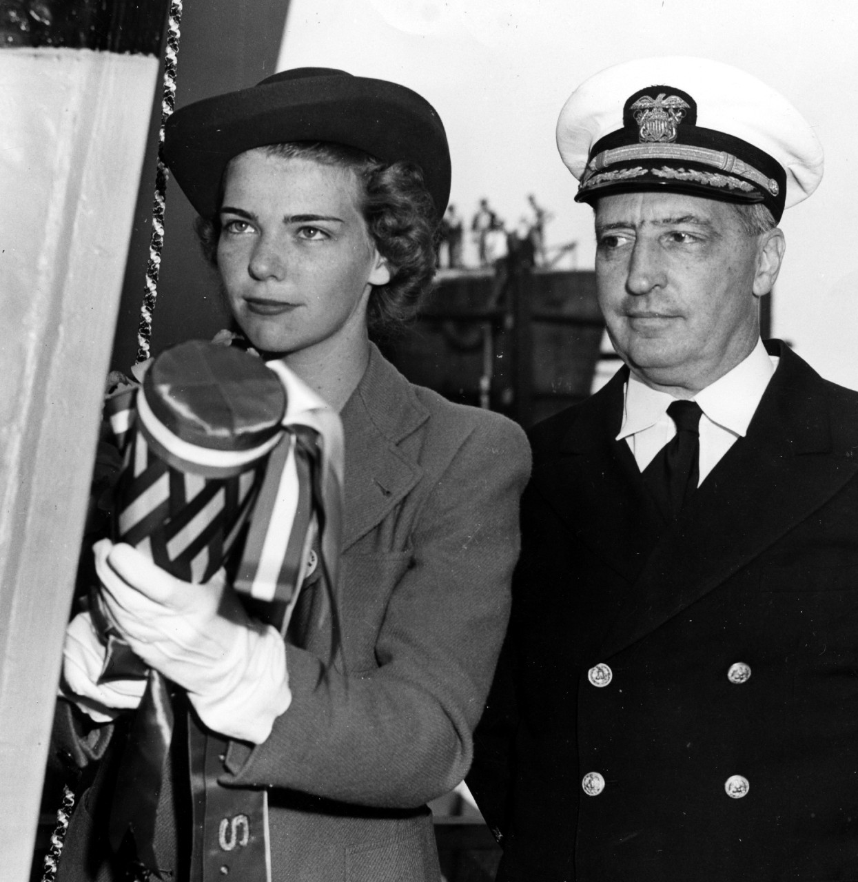 Miss Jeanne Lejeune Glennon (L), holds a bottle of Great Western Reserve Champagne, preparing to christen the ship named for her late grandfather, while Capt. James B. Glennon, her father, looks on (R), 26 August 1942. (U.S. Navy Bureau of Ships ...