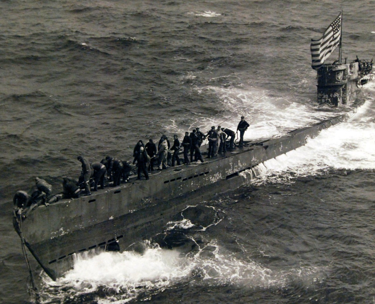80-G-49172: Capture of German Submarine U-505, June 4, 1944. Members of the boarding party from USS Pillsbury (DE 133) secure the tow-line to the bow of the captured German submarine, U-505. Because the sea was sweeping across the deck amidships,...