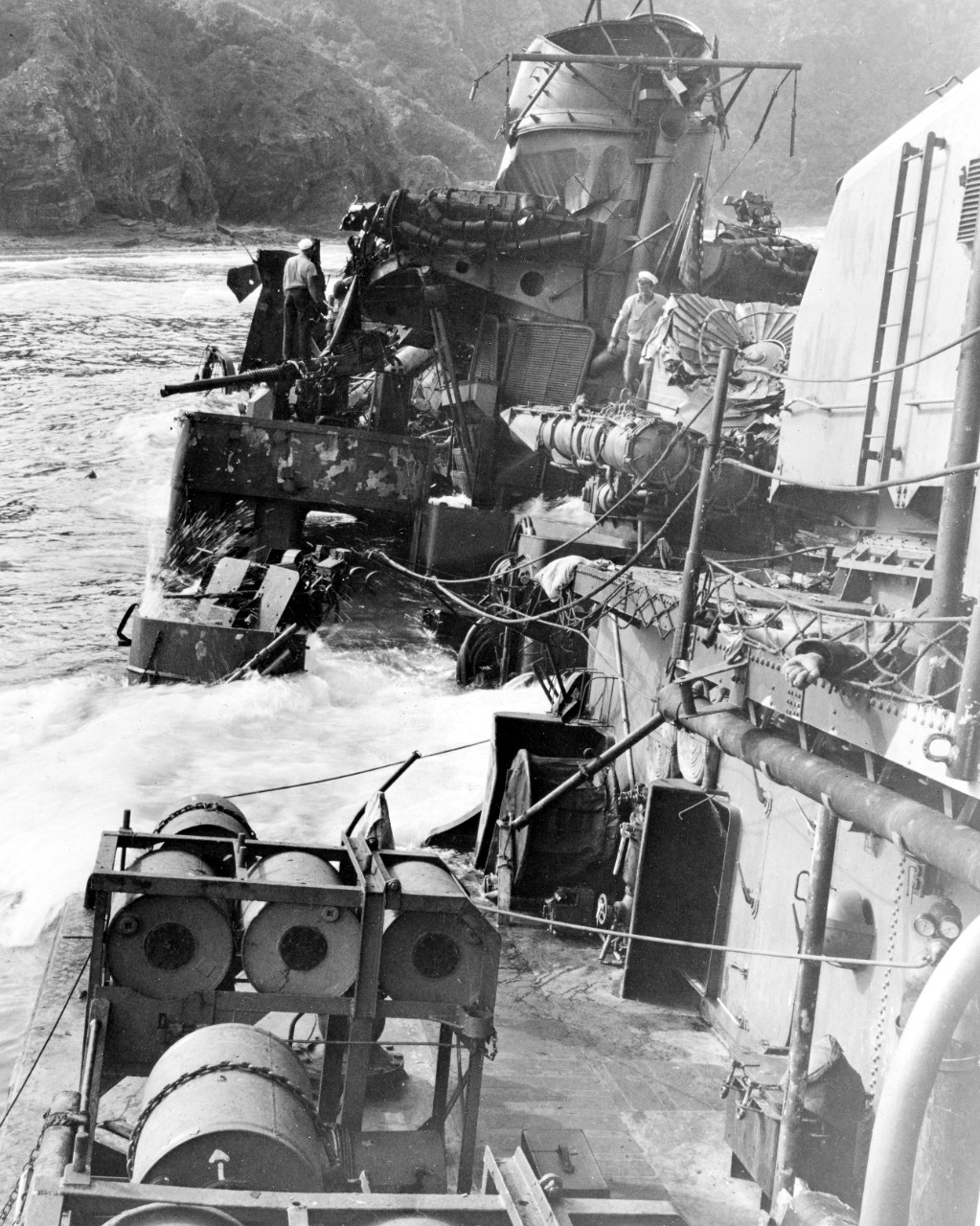 Taken by a member of the inspection party that visited Halligan’s wreck on 28 March 1945, this photo shows the ship down by the bow, the surf breaking over the main deck on the port side, while very little forward of the No. 2 stack (her steaming...