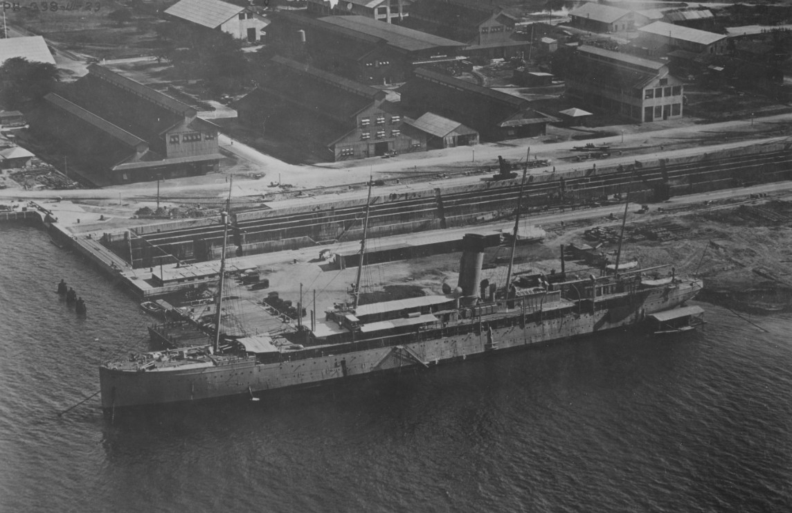Hancock at the Pearl Harbor Navy Yard, 27 November 1923. She was then serving as the yard's Receiving Ship. Dry Dock No. 1 runs horizontally across the middle of the image. (Naval History and Heritage Command Photograph NH 104678)