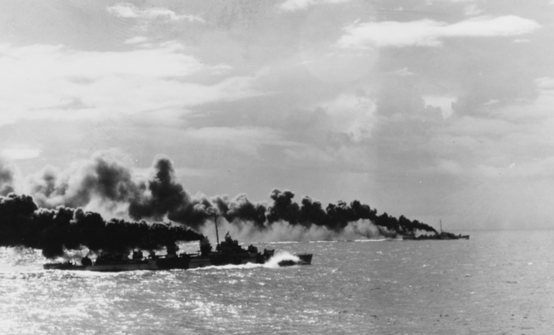 Heermann (steaming in the foreground) makes smoke in an effort to conceal escort carriers in her task force from the Japanese surface fleet during the Battle off Samar on 25 October 1944. Photographed White Plains (CVE-66). (U.S. Navy Photograph ...
