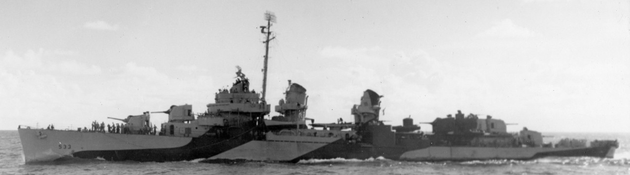 Hoel underway at sea in a camouflage scheme of ocean gray and dull black, 10 August 1944. Note by this point two 40-millimeter twin mounts have replaced the two single-mount 20-millimeters (port and starboard) and the centerline Oerlikon on the p...