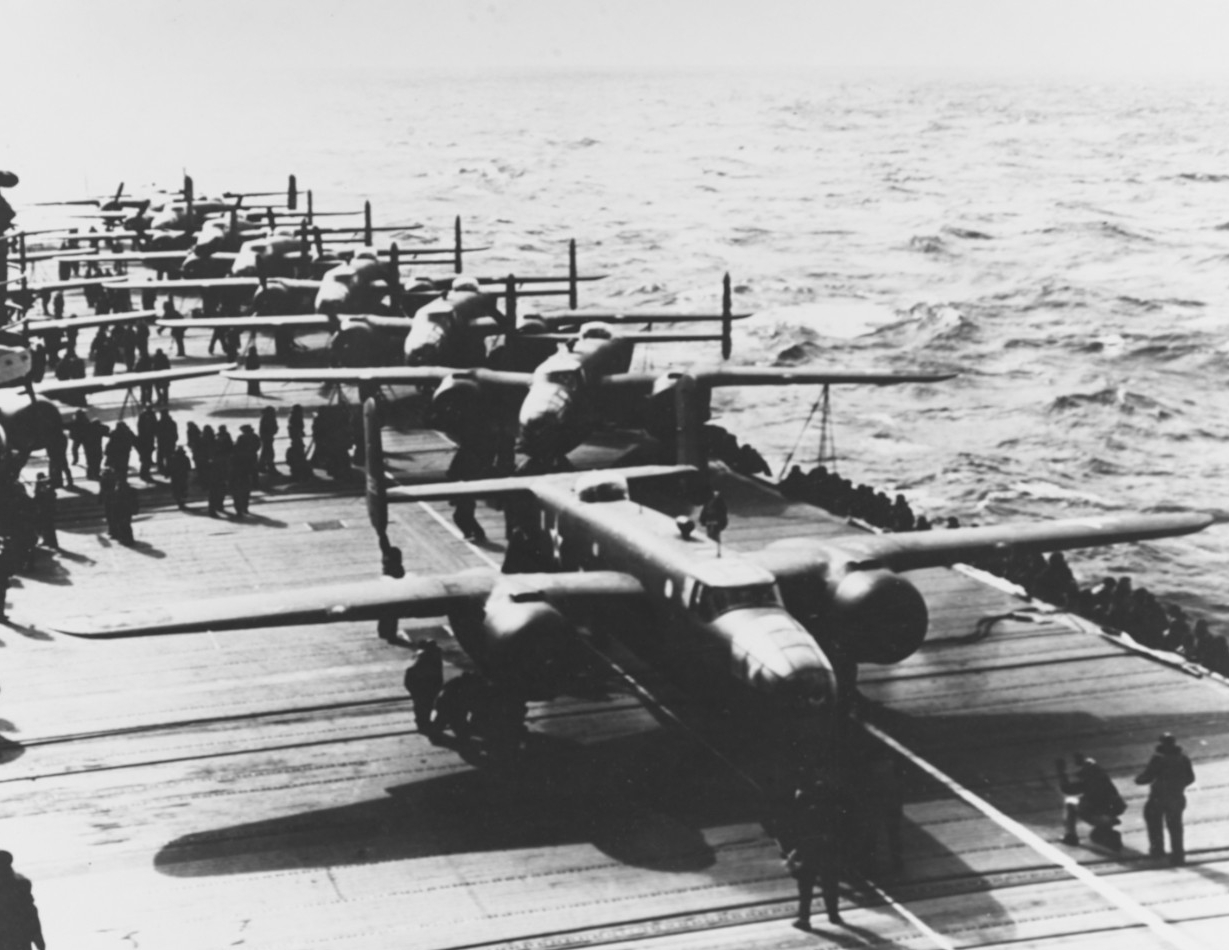 A Mitchell lines up as it prepares to take off to bomb the Japanese home islands, 18 April 1942. This is the 3rd or 4th plane to launch. Note the white lines on to the flight deck, below the bomber’s nose and port side wheels, which guide the pil...