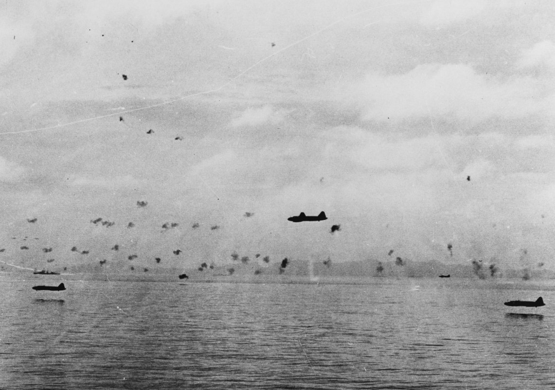 Japanese Mitsubishi G4M1 Type 1 attack planes fly low through Allied antiaircraft fire to attack the transports maneuvering between Guadalcanal and Tulagi, 8 August 1942. The planes carry torpedoes and have had their bomb-bay doors removed, and a...