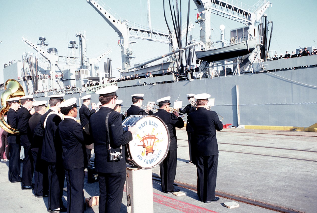 Crewmen line the rails of Kansas City as the San Francisco area Navy band plays for them to celebrate their deployment homecoming, 23 May 1982. (U.S. Navy Photograph DN-ST-82-05161, George Champagne, National Archives and Records Administration, ...