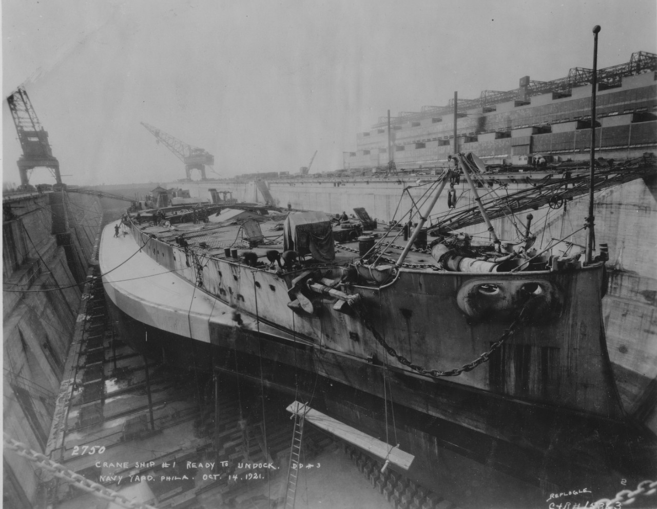 Stripped of turrets, superstructure, and armor, Crane Ship No. 1 is prepared for undocking from Dry Dock No. 3 at the Philadelphia Navy Yard, 14 October 1921. (U.S. Navy Bureau of Ships Photograph 19-N-15363, National Archives and Records Adminis...
