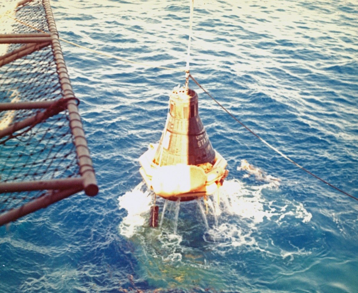 Kearsarge hauls Cooper and Faith 7 on board, 16 May 1963. Once the ship safely lowers the space capsule to the flight deck, the explosive hatch blows out and the astronaut emerges to a tumultuous welcome by the crew. (Naval History and Heritage C...