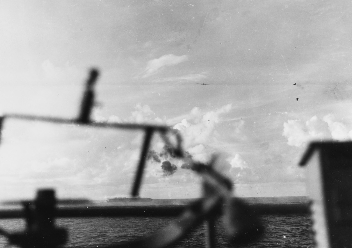 Another enemy twin-engine planes passes over Gambier Bay during the fierce fighting off Saipan, 18 June 1944. Kitkun Bay fights off her attackers in the center of the picture, and another enemy plane is visible under the first one. (U.S. Navy Pho...