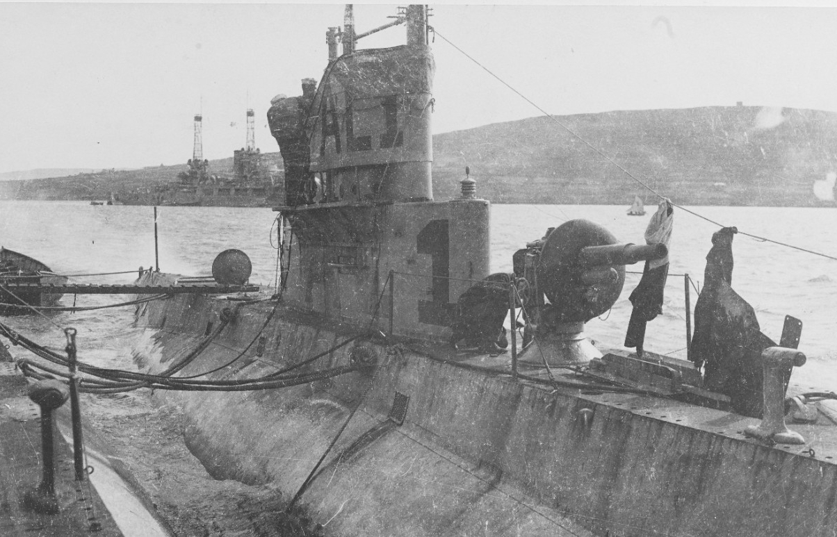 Alongside L-3 (Submarine No. 42) at Berehaven, Ireland, 1918. Nevada (Battleship No. 36), which arrived in Ireland with Oklahoma (Battleship No. 37) on 23 August 1918, is in the background. L-1's 3/23 deck gun is visible in the foreground. Also n...