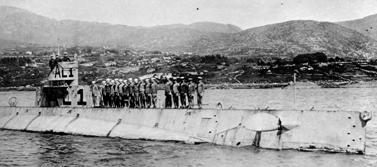 L-1 in Bantry Bay, Ireland, with crew members standing in formation on her foredeck, 1918. Note identification code painted on her fairwater, with AL-1 standing for American submarine L-1 to distinguish her from the British submarine L-1. (Naval ...