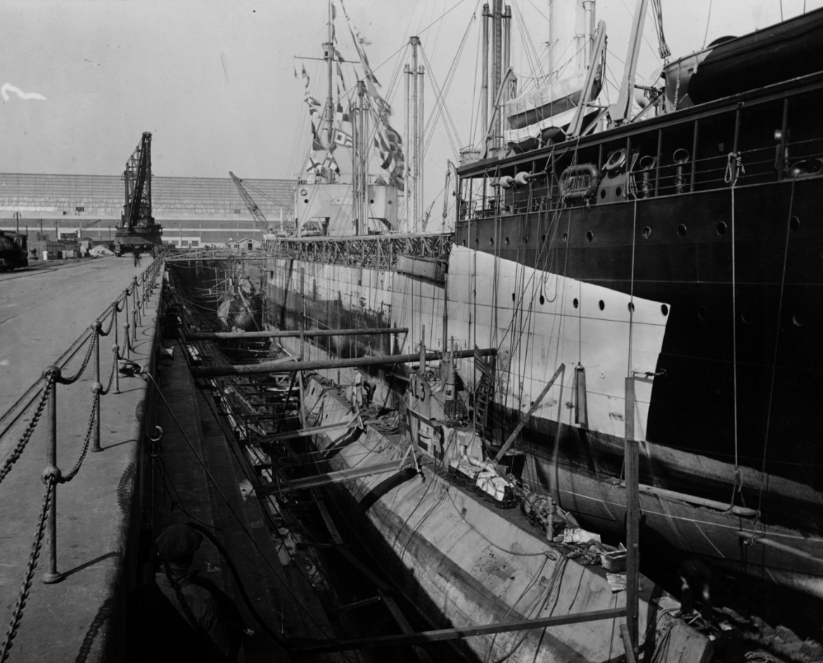 Kanawha (Fuel Ship No. 13) in dry dock at the Philadelphia Navy Yard, 3 March 1919. Two submarines are also in the dry dock, with L-3 in the foreground. Note that Kanawha is still painted in World War I-pattern camouflage. Photographer is probabl...