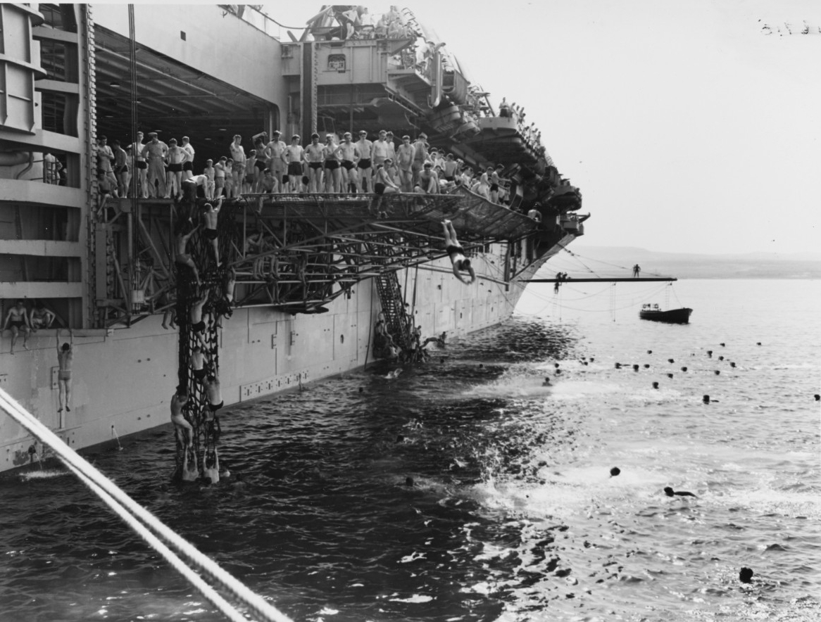 Swim call! Leyte sailors use her deck edge elevator as a diving platform, at Augusta Bay, Sicily, 27 May 1950. (U.S. Navy Photograph 80-G-415936, National Archives and Records Administration, Still Pictures Division, College Park, Md.)
