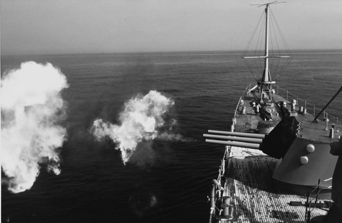 Little Rock firing her 6-inch/47 caliber guns during exercises on the Salto DiGuirra missile range off Sardinia, 23 April 1975. (Naval History and Heritage Command Photograph K-108728)