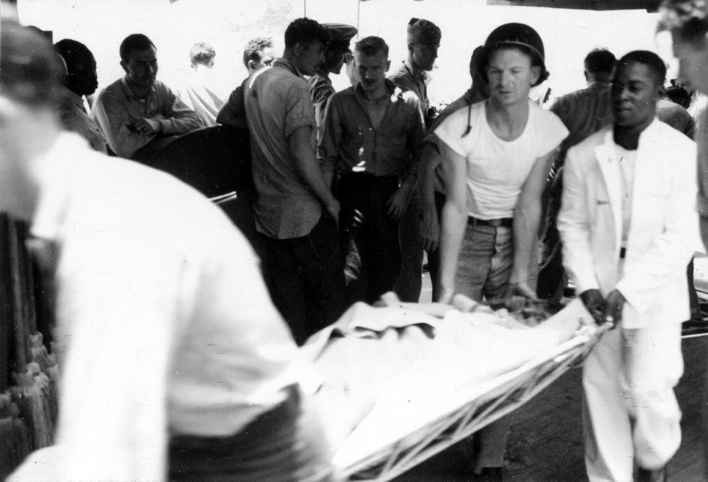 Salt Lake City (CA-25) sailors turn-to to carry a wounded Longshaw bluejacket to receive medical treatment, 18 May 1945. (U.S. Navy Photograph 80-G-343594, National Archives and Records Administration, Still Pictures Division, College Park, Md.)