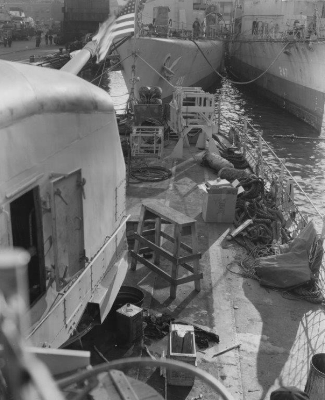 Looking aft from the port side past Madison’s Mt. 55 (left) showing the typical clutter of a yard overhaul, New York Navy Yard, 1 January 1944. Upside-down cardboard National Biscuit Company box (to right of center of photo) appears to have the ship’s identification number [425] marked on it. Charles F. Hughes (DD-428) and Goff (DD-247) lie moored astern, seen beyond the empty depth charge track and CS [chemical smoke] apparatus on the fantail. (U.S. Navy Bureau of Ships Photograph BS 59090, National Archives and Records Administration, Still Pictures Branch, College Park, Md.)