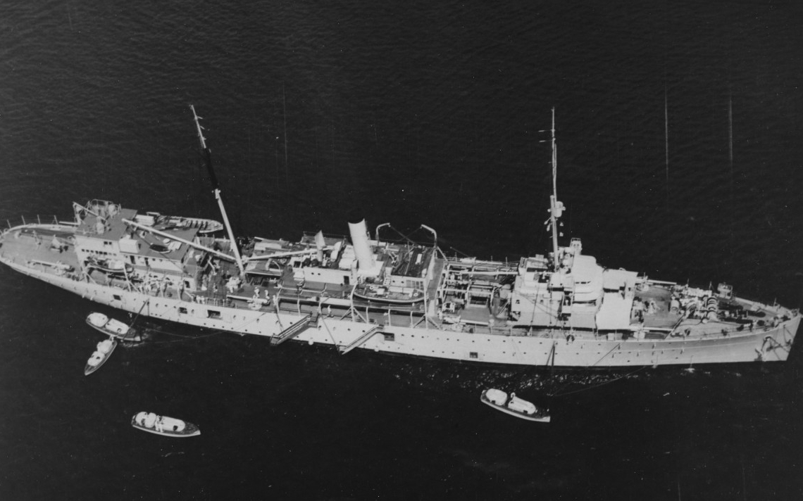 Melville lies moored at Pearl Harbor as seen from an altitude of 800 feet, 23 August 1940. The four boats in the water and the two gangways lowered on her starboard side indicate the constant flow of men arriving and departing. (U.S. Navy Photogr...