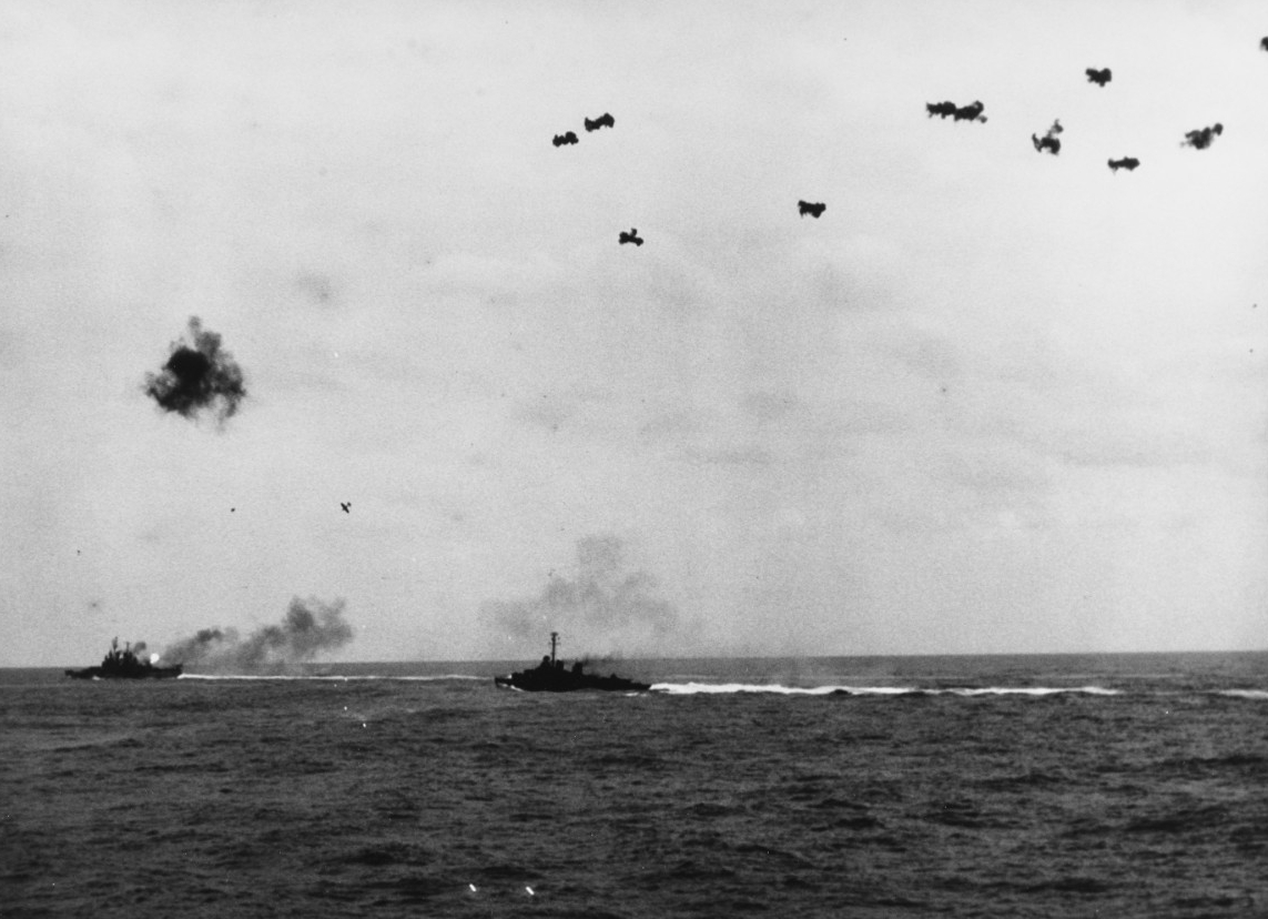 The ferocity of the defense against an attack by a kamikaze is seen here as viewed from Miami (her tracers can be seen at center) as a Mitsubishi A6M5 Zeke plunges through antiaircraft fire in an attempt to crash sister ship Vincennes off Okinawa...