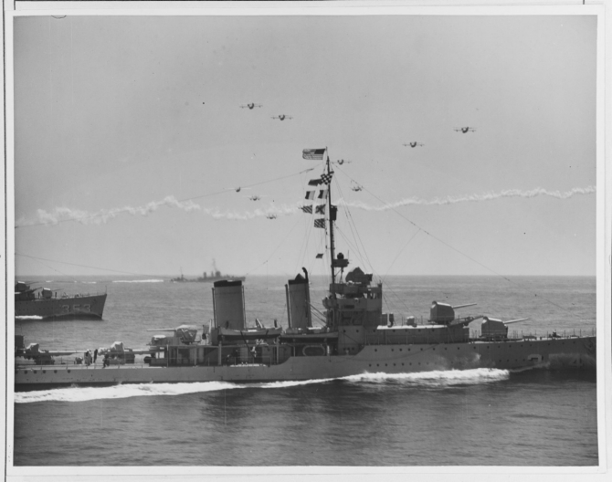 Patrol planes of VPs 7F, 9F, and 11F, operating from seaplane tender Wright (AV-1), fly a massed formation over Monaghan (foreground) and Dale, 14 September 1936. Monaghan’s bow cuts deeply into the water as she makes speed while maneuvering. (Naval History and Heritage Command Photograph NH 67281)