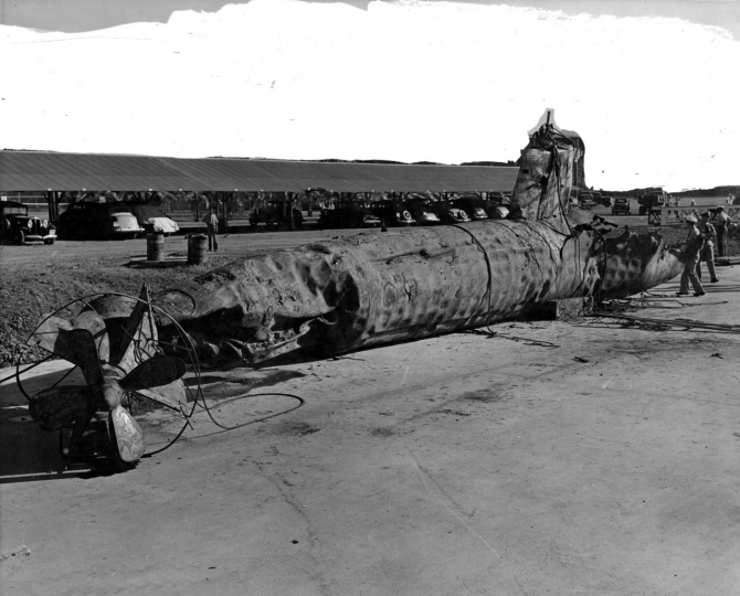 The Navy raises I-22tou’s battered hulk at Pearl Harbor. The submarine’s hull shows the effects of Monaghan’s depth charges and ramming. A hole visible in the after part of the conning tower may be from a 5-inch shell. The upper background has been overpainted for censorship purposes. (Naval History and Heritage Command Photograph NH 54302)
