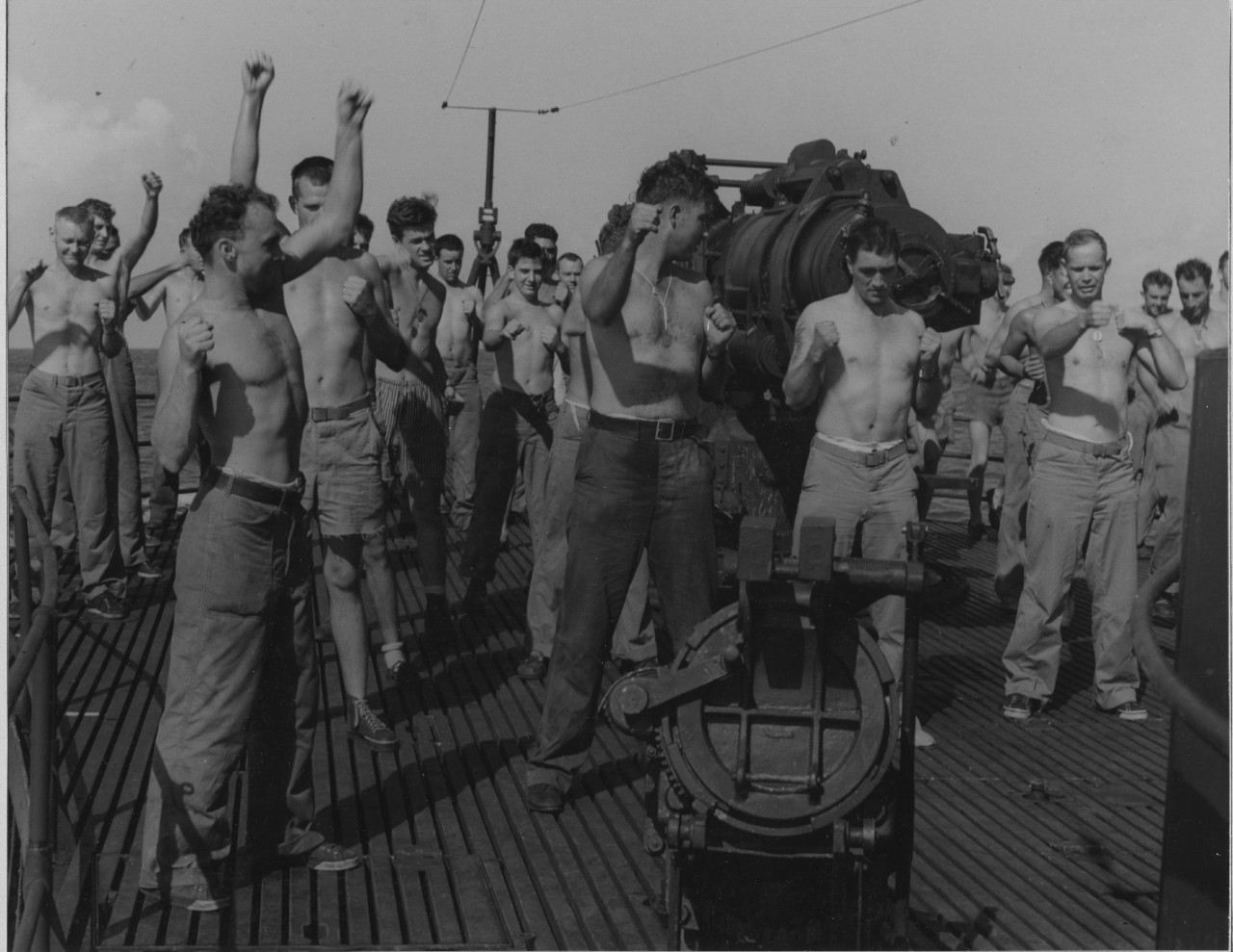 Marine raiders, probably welcoming the chance to be out in fresh air, limber up topside around Nautilus’s forward 6-inch gun during the voyage to the Gilberts, 11 August 1942. Note the tattoed Leatherneck working out to right of center. Sadly, no...