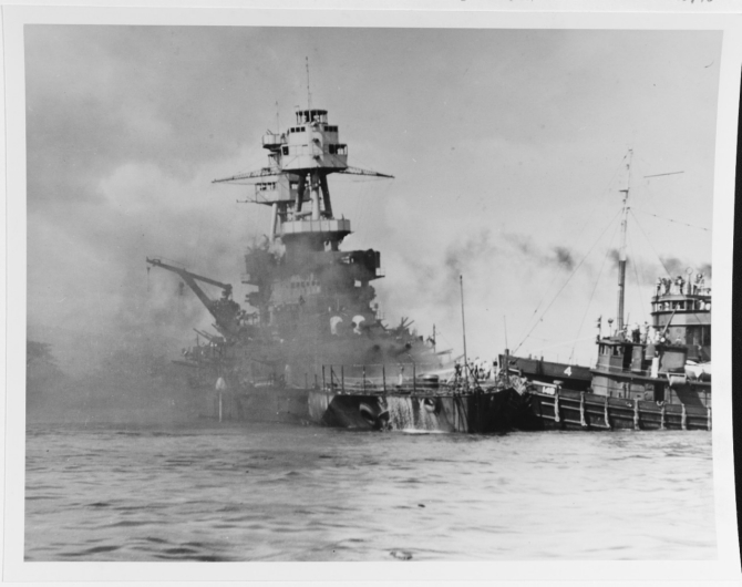 Nevada aground and burning off Waipio Point, after the end of the Japanese air raid. Ships assisting her, at right, are the harbor tug Hoga (YT-146) and the tender Avocet (AVP-4). (U.S. Navy Photograph 80-G-33020 National Archives and Records Administration, Still Pictures Division, College Park, Md.)