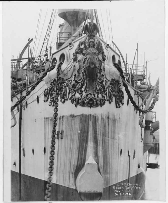 A bow shot of the ship while at Boston Navy Yard shows her gilded bronze figurehead, sculpted by Augustus Saint-Gaudens and commemorating her victory at Manila Bay, 4 November 1901. (Courtesy of Bureau of Construction and Repair, 1925, U.S. Navy Photograph NH 43048, Photographic Section, Naval History and Heritage Command)