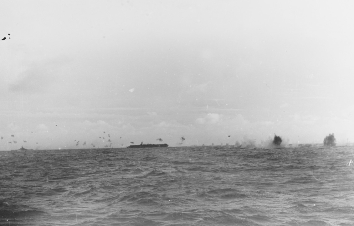 Ships’ antiaircraft guns fill the sky with flak bursts as a Japanese plane crashes not far from Princeton off Formosa, 14 October 1944. The battleship in the distance is most likely Alabama (BB-60) or South Dakota (BB-57). (U.S. Navy Photograph 8...