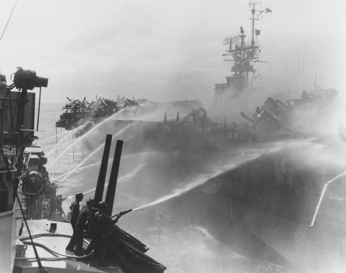 Crewmen on board Birmingham play fire hoses onto the burning carrier as the cruiser closes to render assistance, 24 October 1944. (U.S. Navy Photograph 80-G-270357, National Archives and Records Administration, Still Pictures Division, College Pa...