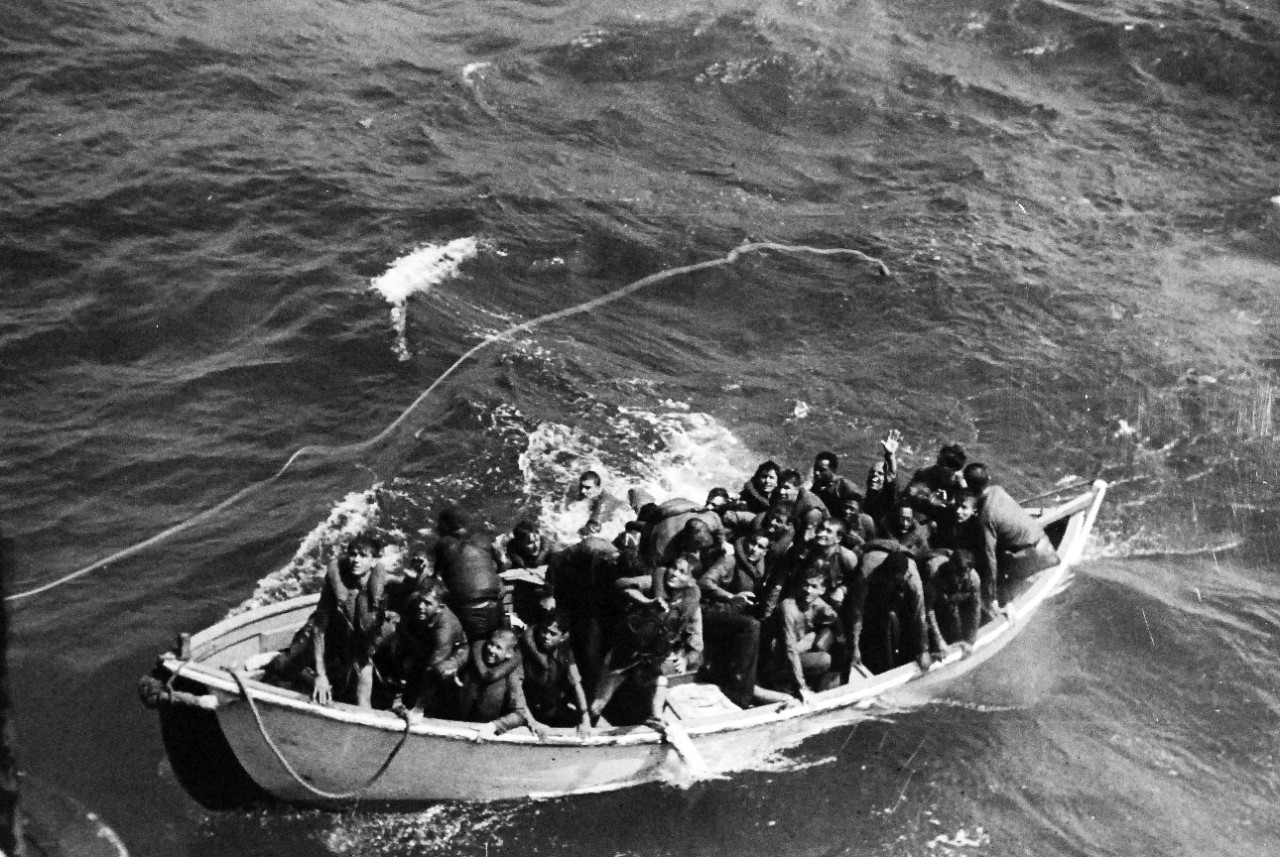 80-G-281662: USS Princeton (CVL-23), October 24, 1944. Survivor of USS Princeton (CVL 23) adrift in life boat at sea as seen from USS Cassin Young (DD-793). 