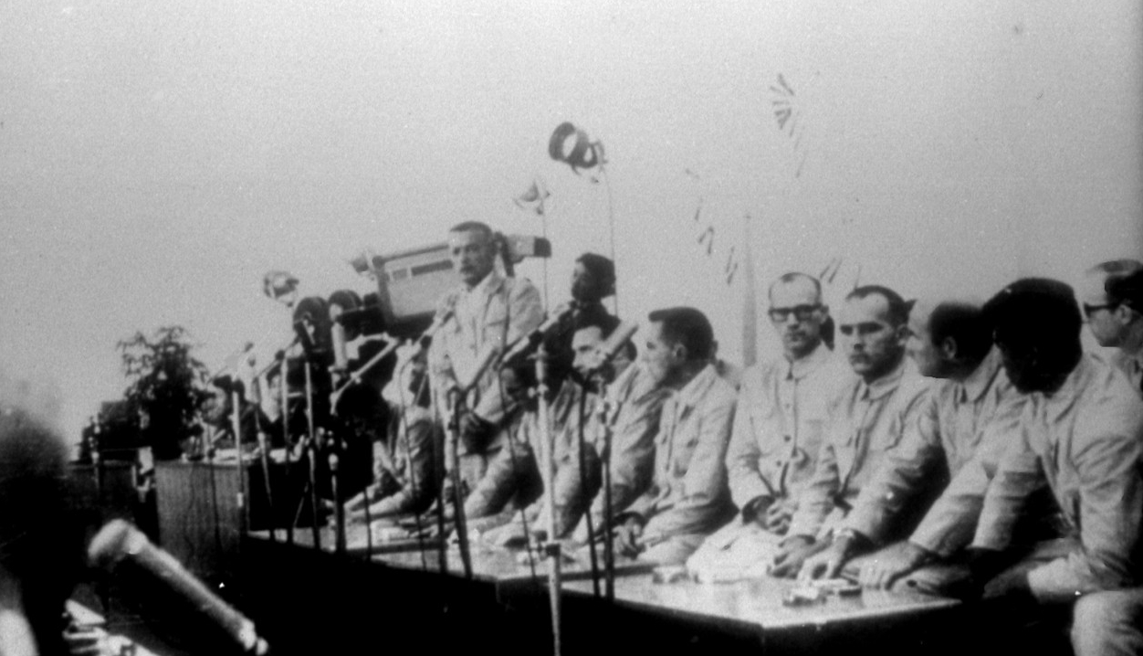 The North Koreans take this propaganda photograph of some of the Pueblo crewmen at a press conference in North Korea, sometime after they capture them. Cmdr. Bucher stands in the center. (Naval History and Heritage Command Photograph NH 75557)