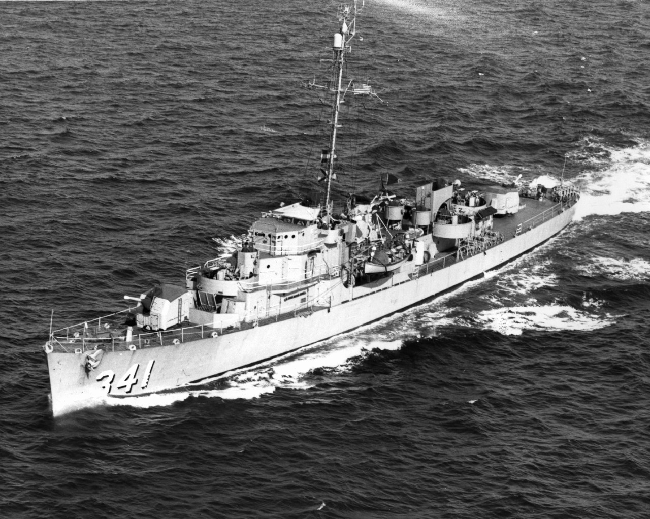 Painted in peacetime colors, Raymond is seen here underway at sea, most likely in the 1950s, her identification number in large black-shaded white numerals at her bow. All 20-millimeter guns have been removed by this point, but the twin 40-millim...