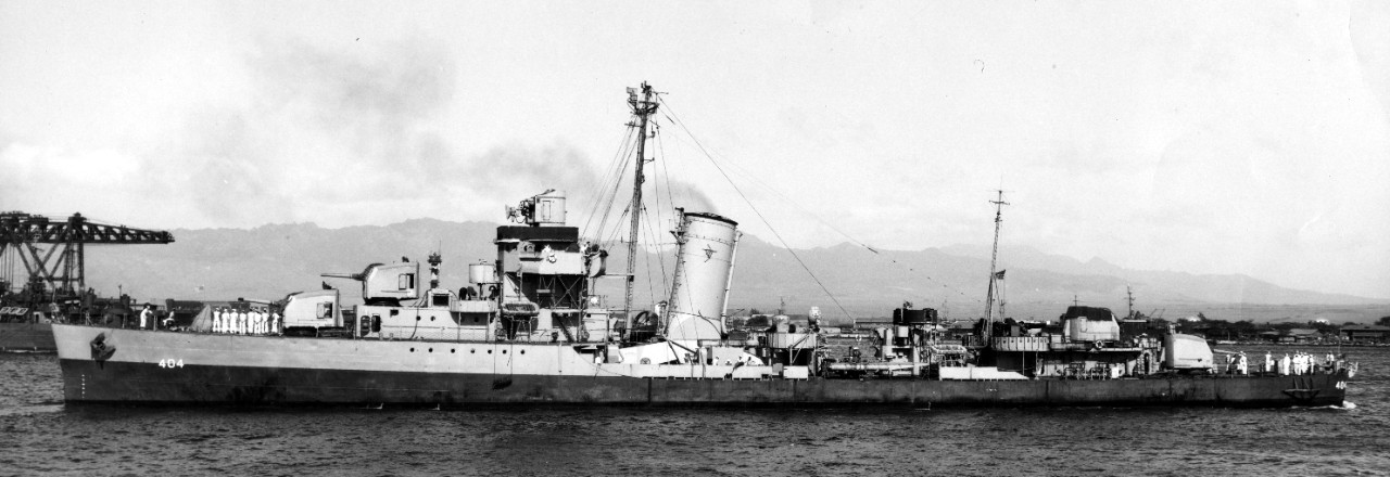 Rhind, once more wearing graded system camouflage, backs out of her berth at the Pearl Harbor Naval Shipyard, 17 March 1946. (U.S. Navy Bureau of Ships Photograph BS 114538, National Archives and Records Administration, Still Pictures Division, C...