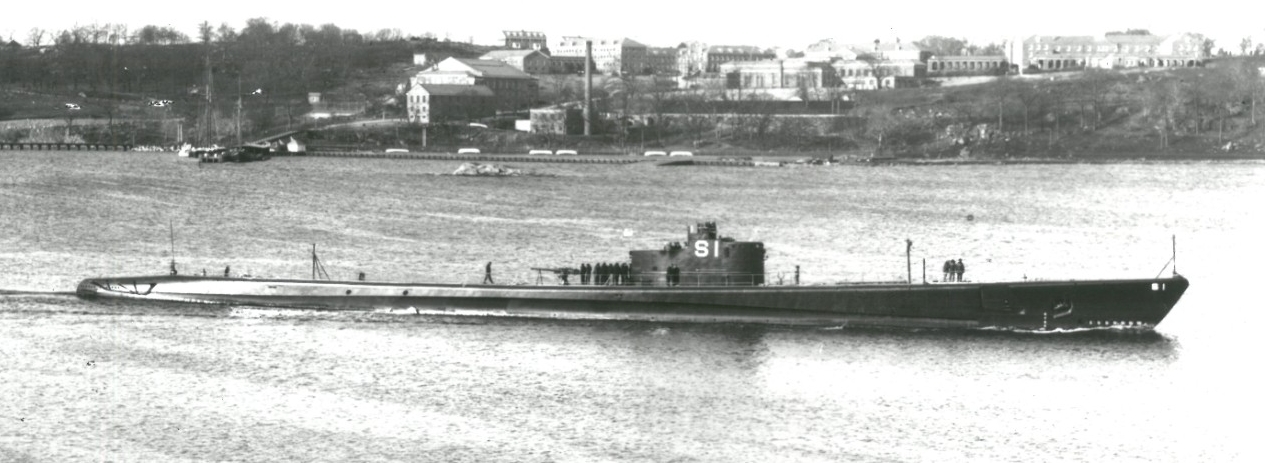 The newly commissioned submarine presents a sleek profile as she stands down the Thames, 15 March 1938. Note the sailors standing attention, and the man carefully walking along her hull aft toward the sail. (U.S. Navy photograph, Salmon (SS-182),...