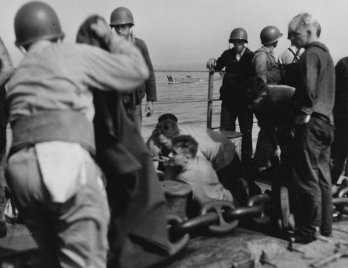 Some of the ship’s medical team tend the wounded at an improvised first aid station on the forecastle. (U.S. Navy Photograph 80-G-54355, National Archives and Records Administration, Still Pictures Division, College Park, Md.)
