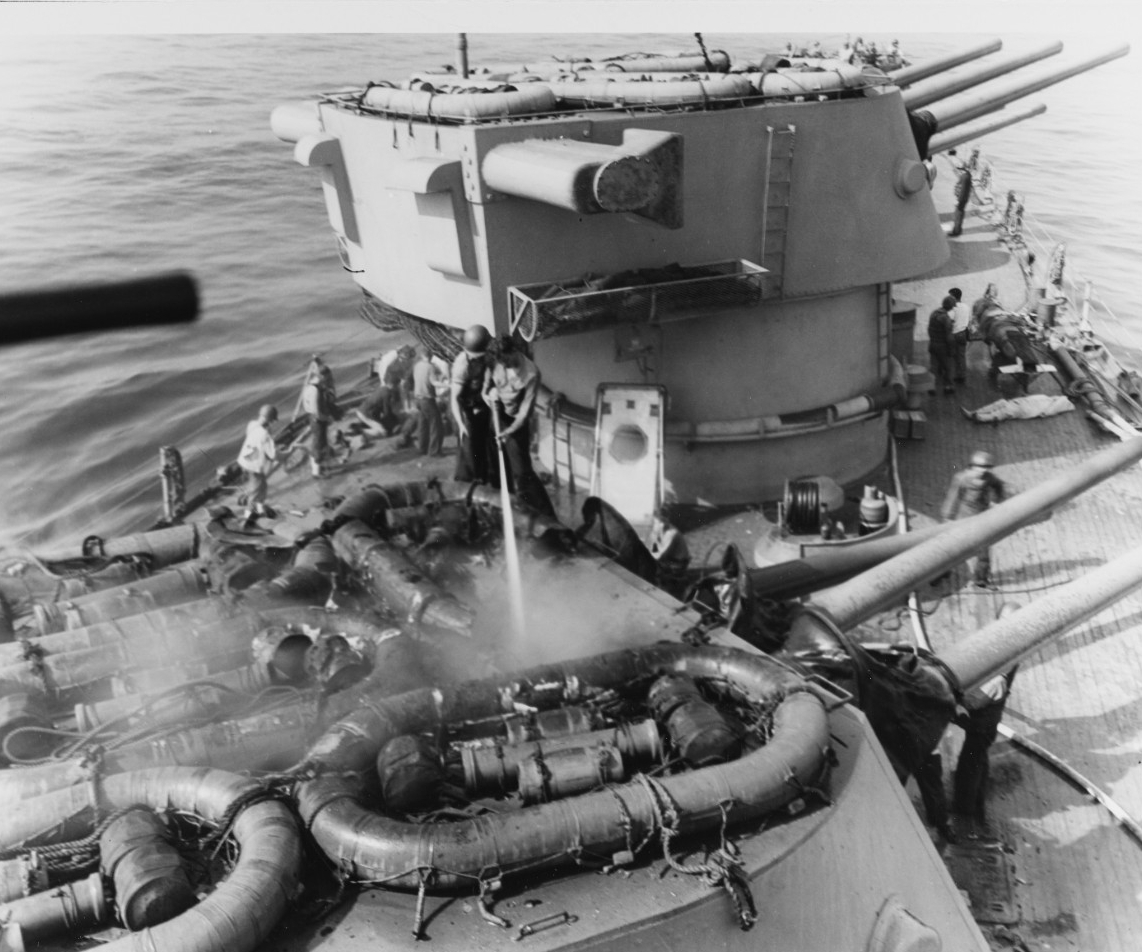 Crewmen spray water into the smoldering turret, and their fellows mournfully lay out casualties (to the right of the picture). (U.S. Navy Photograph 80-G-54357, National Archives and Records Administration, Still Pictures Division, College Park, Md.)