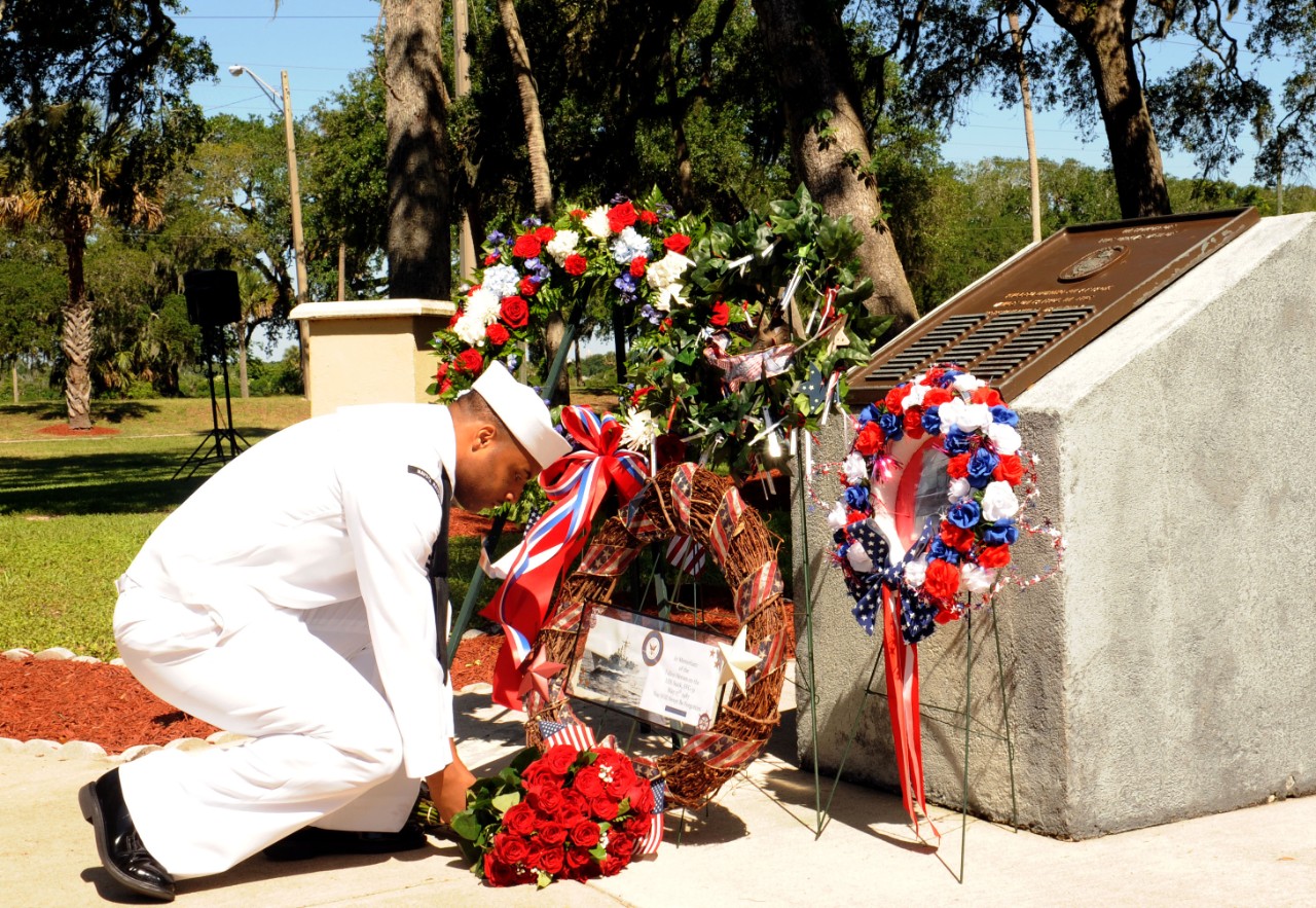 Yeoman 2nd Class DeMario Smith reverently places flowers at the Stark Memorial during the ceremony at Mayport, 16 May 2014. (Mass Communication Specialist 2nd Class Damian Berg, U.S. Navy Photograph 140516-N-TC587-072, Navy NewsStand)