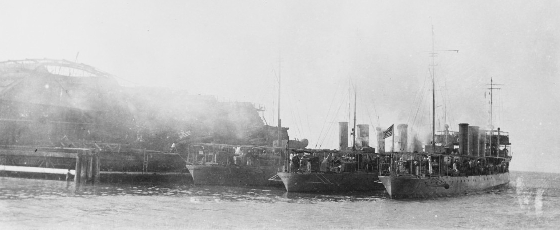 Destroyers coaling at Dry Tortugas, Fla., 15 March 1914. Members of the Second Division, Torpedo Flotilla, Atlantic Fleet, these ships are (from left to right): Monaghan (Destroyer No. 32); Sterett (Destroyer No. 27); and (perhaps) Terry (Destroy...