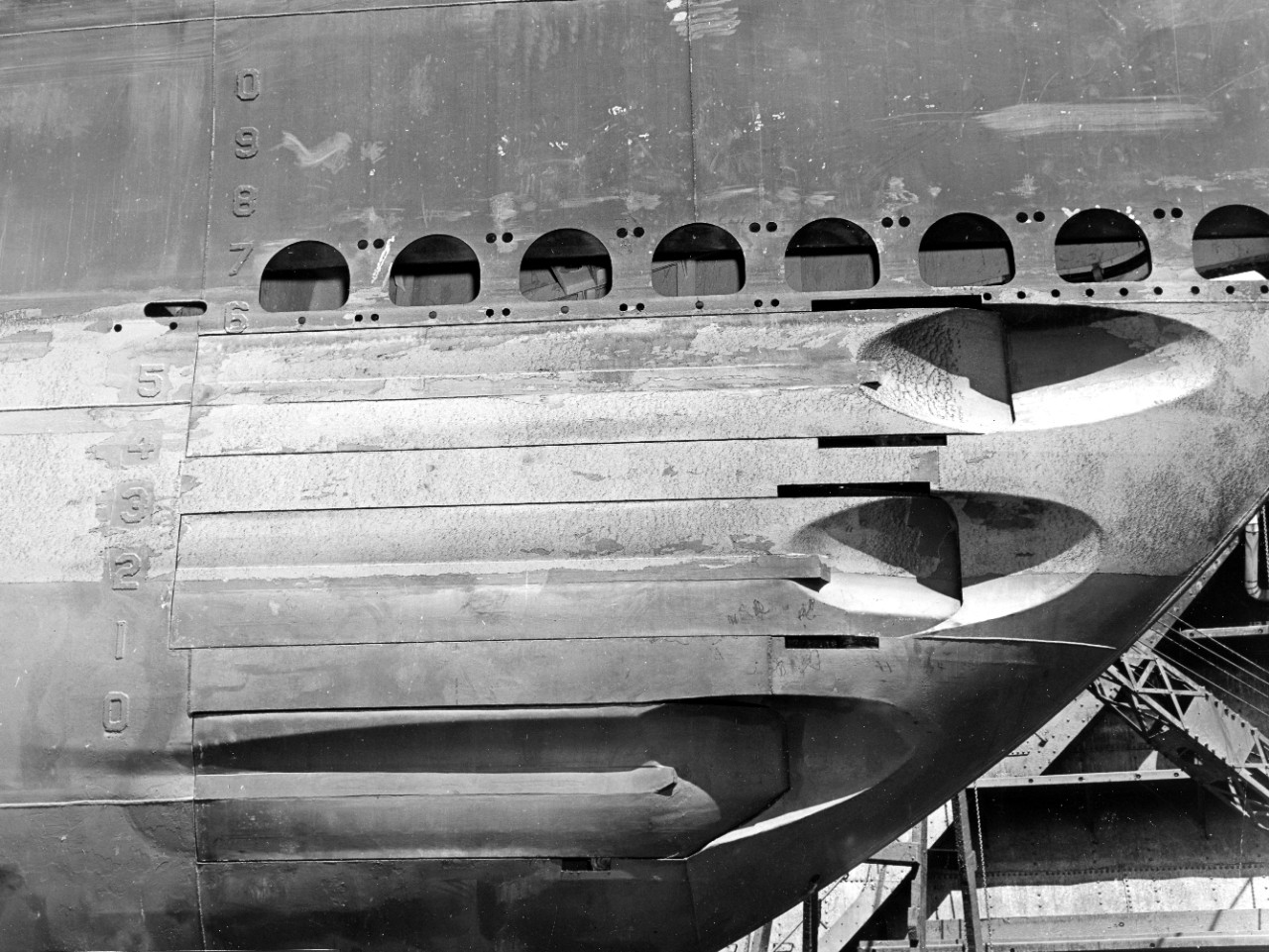 Tullibee’s forward torpedo tubes, this view showing the starboard bow tubes with the shutters in the closed position. Note the draft marks welded onto the hull, painted the same color as the surrounding hull, Pearl Harbor Navy Yard, 24 May 1943. ...
