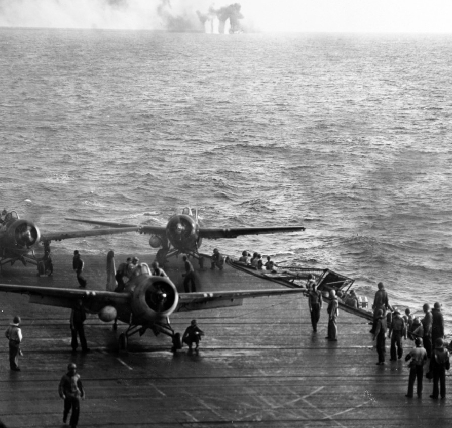 Men scramble to launch Wildcats as the enemy surprises Kitkun Bay off Samar, 25 October 1944. The fighter on the port quarter of the ship’s flight deck turns quickly to get into the action as the planes launch rapidly in the desperate circumstanc...