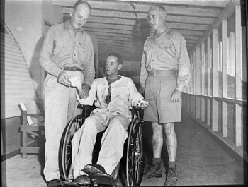 CDR Eugene Own examines dressings of Dr. Haynes at Naval Hospital Guam. CAPT McVay stand at right--BUMED Archives