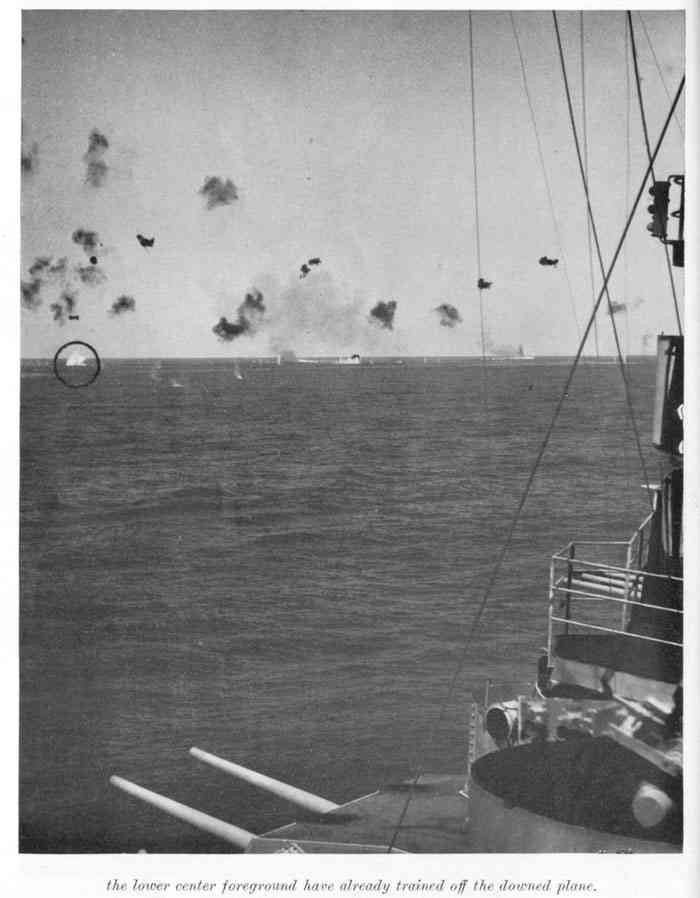 Splash of Japanese plane seen in two preceding photos taken a few seconds earlier. AA guns in the lower center foreground have already trained off the downed plane.