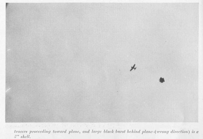 Japanese fighter plane ("Zeke") under pre by AA batteries. White spots indicate machine gun tracers proceeding toward plane, and large black burst behind plane (wrong direction) is a 5" shell.