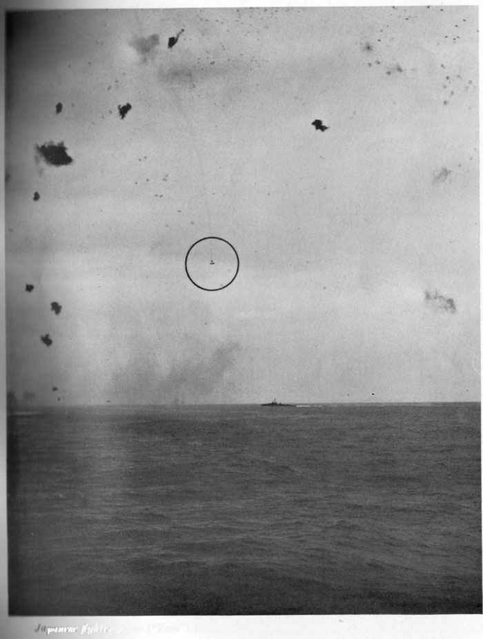 Japanese fighter plane ("Zeke") falling in flames near destroyer. AA fire is accurate.