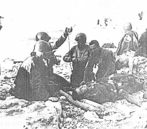 Army "medics" treat a casualty on Fox Green beach. Heavy casualties to the assault troops would have been much higher but for DESRON 18 and other fire support ships.