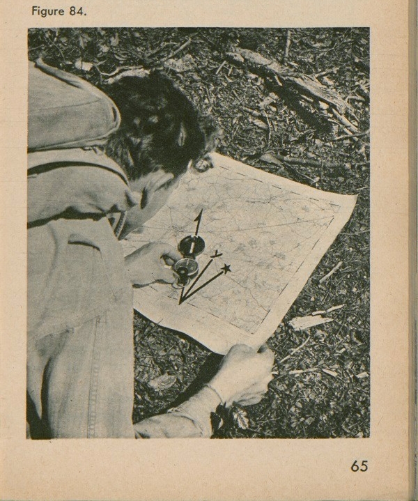 Figure 84: A man looking at map with a compass on top and a declination diagram.